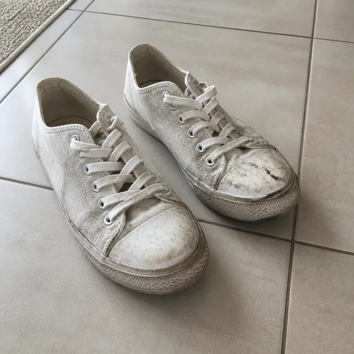 Pair of scuffed and dirty white trainers before cleaning